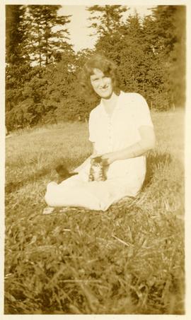 Marjorie Martin sitting on lawn with two kittens on her lap at Wilkinson Road